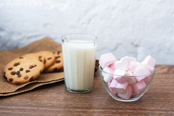 Fragrant, tasty, homemade cookies with raisins, marshmallows in the form of hearts and a glass of fresh milk on the table. Delicious, hearty, healthy breakfast. Copy space, high resolution
