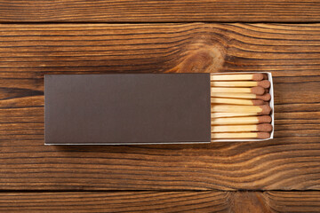 top view brown color matchbox with brown match sticks on a wood table