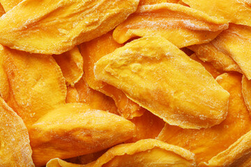 Pieces of sweet dried mango close-up as a background in full screen