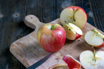 cutting old board with pieces of red ripe apple
