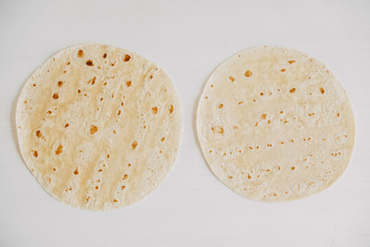 Thin pita bread on a white wooden table background