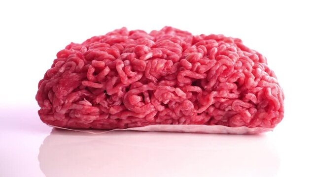 Rohes Hackfleisch auf einem Drehteller - Rinderhack freigestellt auf wei&szlig;em Hintergrund 