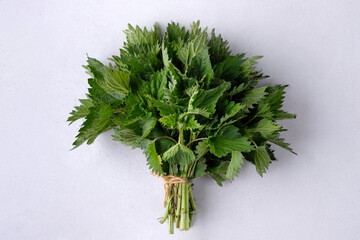 A bouquet of nettles on white concrete background. Concept of broken love, frustration and...