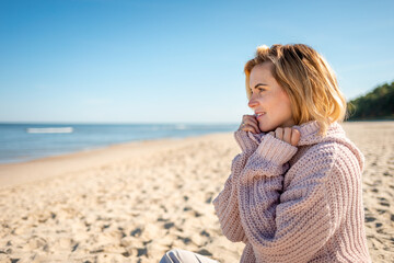 Beautiful woman relaxing on empty beach after season