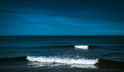 Calm night seascape with white waves