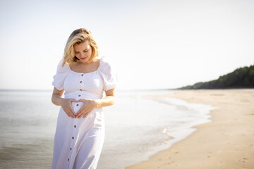 Happy pregnant woman spending time on a beach