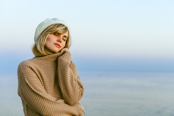 Portrait of beautiful young woman at cold day on sea shore