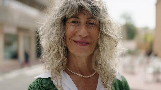 Middle age woman smiling confident standing at street