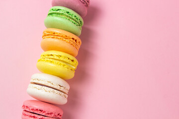 Colored macarons on a pink background. Light and tasty dessert. traditional dessert