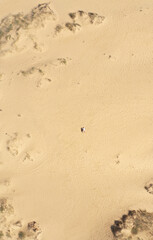 Fototapeta na wymiar Aerial view of a young couple lying on the white sand. man and woman spend time together and travel through the desert