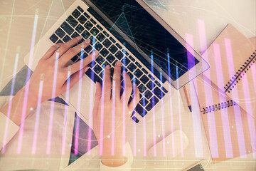Double exposure of woman hands working on computer and forex graph hologram drawing. Top View. Financial analysis concept.