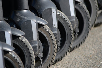 Partial view of seven electric scooter in a diagonal row.