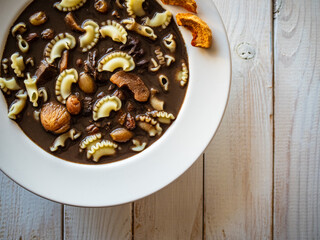 Blood soup with offal and sun dried fruits on wooden table