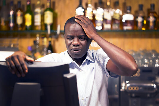 African bartender made a mistake in the bill, emotion. African barmaid registrating new order by cash register