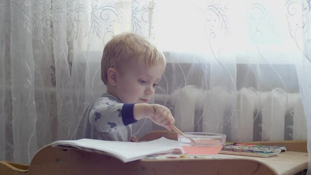 Three years old caucasian Boy Drawing with Felt-tip pen. Little Boy Having Fun Paints Picture On Paper. Kid Being Creative and Artistic. Child Education at Home indoor. Creative Preschooler Study 4K