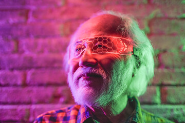 Asian senior man using virtual reality glasses indoor - Elderly person having fun with modern technology