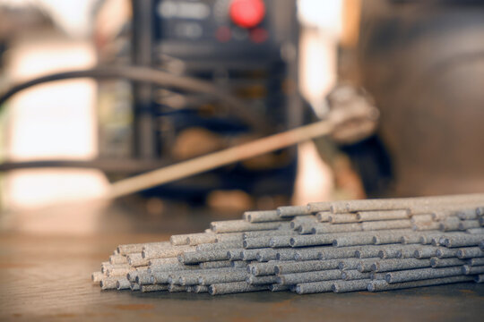 Welding electrodes extended from the bundle against the background of welding equipment