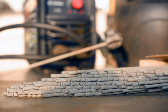 Welding electrodes extended from the bundle against the background of welding equipment
