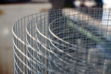 Construction grid with a square cell rolled into a roll. Close-up selective focus. A roll of mesh...