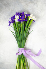 bouquet of lilac and white irises on a grey background. Vertical view.