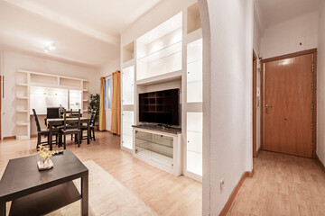 Entryway to a living room with a dark wood dining table and matching chairs with yellow accents to match the curtains in a vacation rental apartment