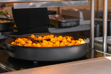 Traditional Polish potatoes with pork rinds in a large frying pan at a food festival in Krakow