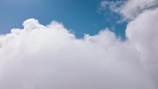 Cinematic breathtaking aerial flying backwards through white clouds in heavens