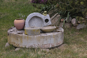Obraz premium Vintage grain mill used as a garden decoration