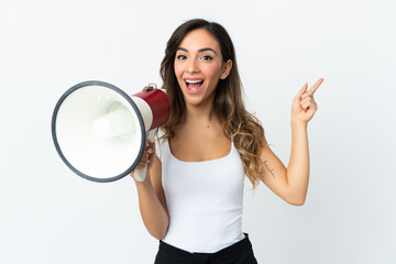 Young caucasian woman isolated on white background shouting through a megaphone and pointing side