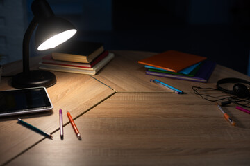 table with digital tablet with blank screen on table with colorful drawing supplies