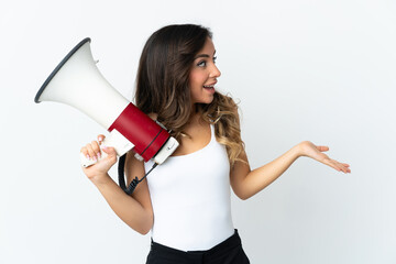 Young caucasian woman isolated on white background holding a megaphone and with surprise facial expression