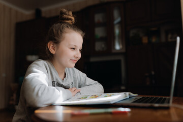 Cute girl with pc and book indoors. Education, technology and children concept