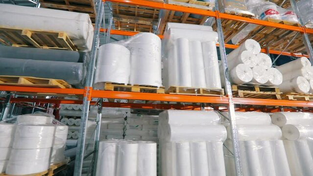 Warehouse with rolls of nonwovens. Large warehouse in a nonwoven fabric factory. Large roll of spunbond