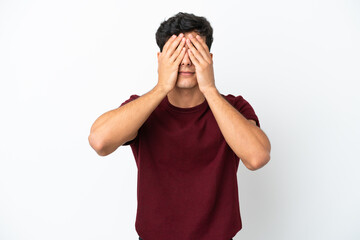Young Argentinian man isolated on white background covering eyes by hands