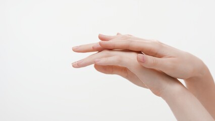 Close-up shot of female hands touching each other on white background | Hand care and skin moisturizing concept