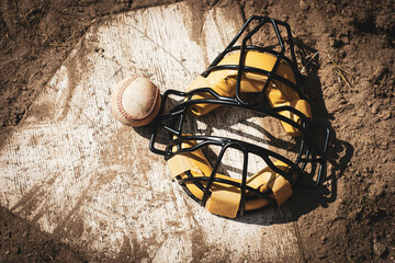 Baseball and catcher mask on home plate
