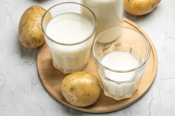vegan potato milk in glass and raw potato. Alternative plant based milk. superfood concept....