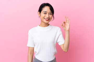 Young Vietnamese woman isolated on pink background showing ok sign with fingers