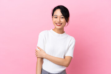 Young Vietnamese woman isolated on pink background laughing