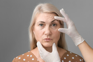 elderly woman doing cosmetology procedures botox injections in the forehead