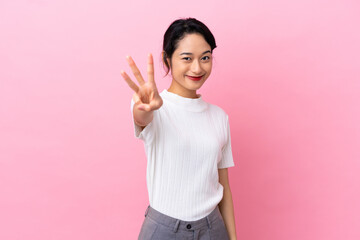 Young Vietnamese woman isolated on pink background happy and counting three with fingers