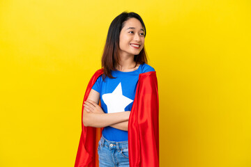 Super hero Vietnamese woman isolated  on yellow background with arms crossed and happy © luismolinero