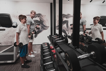 Fototapeta na wymiar Father and son train together at home gym. The concept of healthy life. Selective focus