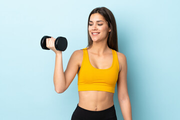 Young caucasian woman making weightlifting isolated on blue background with happy expression