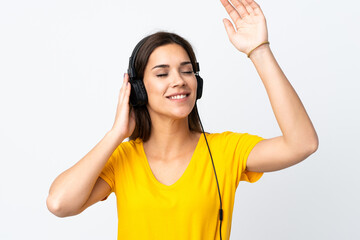 Young caucasian woman isolated on white background listening music and dancing