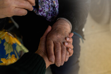 Mani di ragazza e di anziana