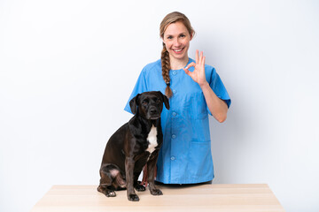 Young veterinarian woman with dog isolated on white background showing ok sign with fingers