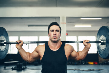 Lifting is not an act but a habit. Shot of a man lifting weights at the gym.