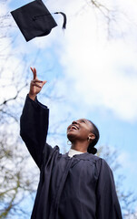 Upwards and onwards from here on. Shot of a young woman throwing her hat in the air on graduation...