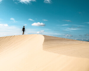 Fototapeta na wymiar Homem caminhando na areia das dunas em tutoia, Maranhão 